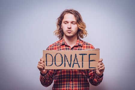 male, cardboard sign donation. On a gray backgroundの写真素材