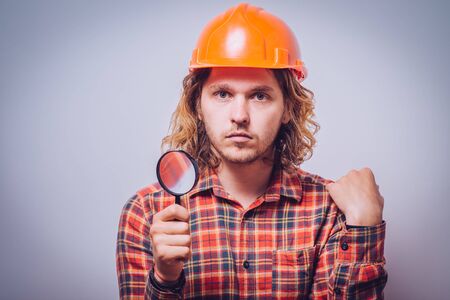 builder with magnifying glassの写真素材
