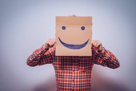 man, holding a picture with a cheerful smileyの写真素材