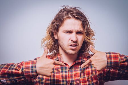 Male hand forefinger pointing to himself on the chest. Gesture. who am i. On a gray backgroundの写真素材