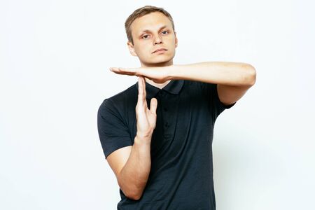 A man shows the hands stop timeout. On a gray background.