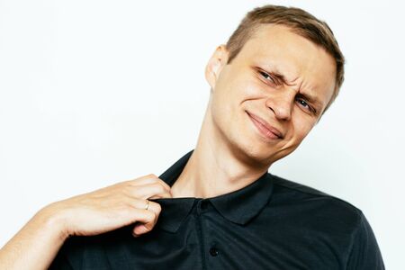 Closeup portrait of young man opening shirt to vent,it's hot. Negative emotion, facial expression,...