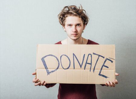 man, holding a picture with the inscription donateの写真素材