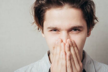 A young man holding back vulgar jokes