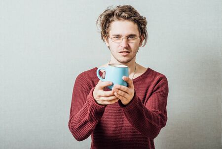 Portrait of handsome young man with cup