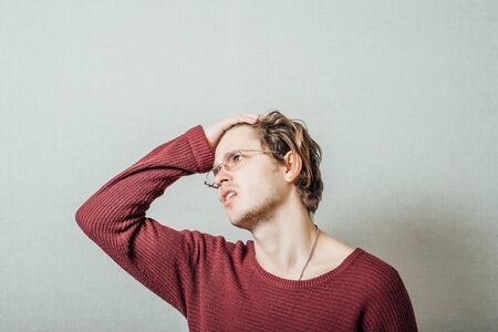 Young businessman holding head in his handsの写真素材