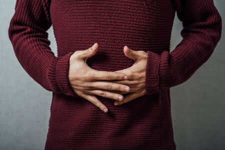 man holding his stomach in pain or indigestionの写真素材