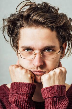 The man with glasses tired sleepy. On a gray background.