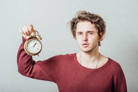 man holding an alarm clock in handsの写真素材