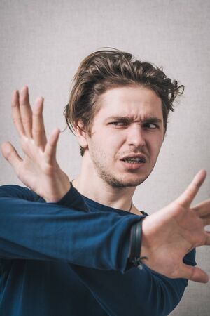 A man shows the hands stop timeout. On a gray background.
