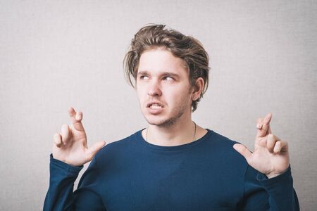 man crossed her fingers for luck. Gray backgroundの写真素材