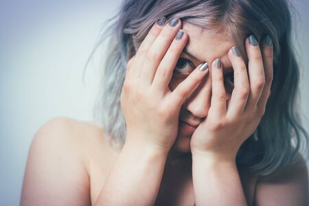 Woman covers his face by handの写真素材