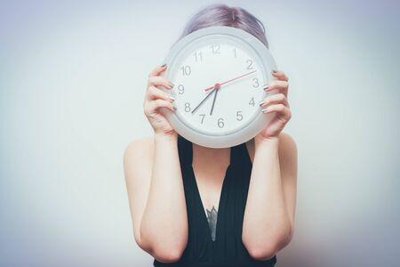 Woman holding clock close up.
