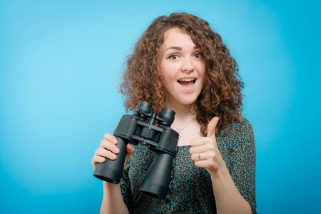 portrait of young girl looking through a binoculars