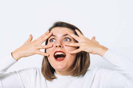 The woman covers her face with her hands and peepsの写真素材