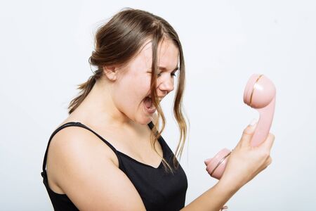Portrait of a woman yelling at phoneの写真素材
