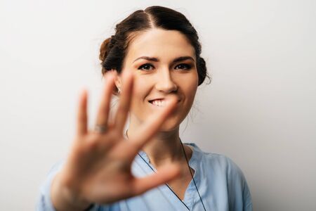 Pretty brunette girl showing five fingersの写真素材