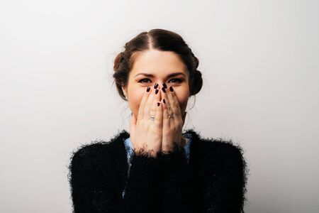 girl covers her mouth with her handsの写真素材