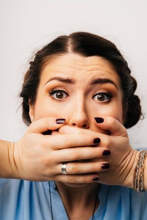 girl covers her mouth with her hands