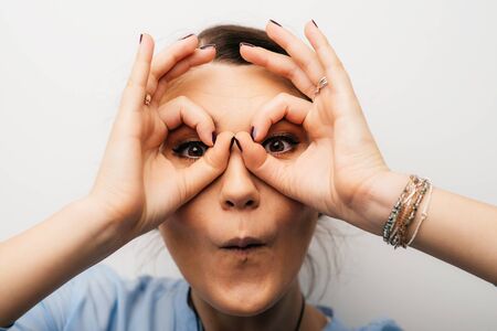 Pretty brunette girl shows glasses handsの写真素材