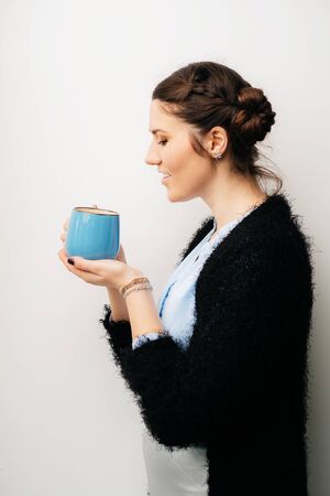 Woman with big blue cup, drink tea or coffee. Profile. Isolated on a white backgroundの写真素材
