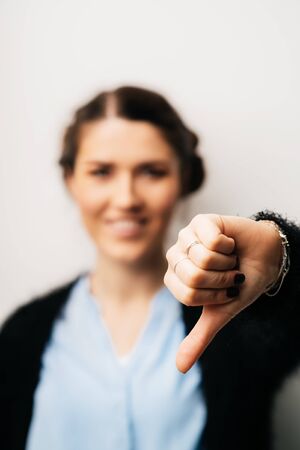 Woman offended or upset lowered thumb down. Isolated on a white backgroundの写真素材