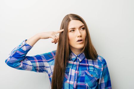 young woman thinks his finger to 
temple