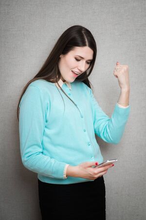 Happy gesturing young cheerful smiling business woman with phone or support operator, showing okay gesture, isolatedの写真素材