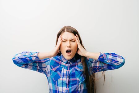 long-haired beautiful girl is very upset and holding his head, isolated on white backgroundの写真素材