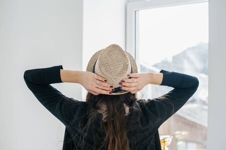 back of a young girl with long hair in a hatの写真素材