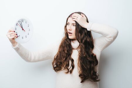 on a white background girl holding a clock in  handsの写真素材