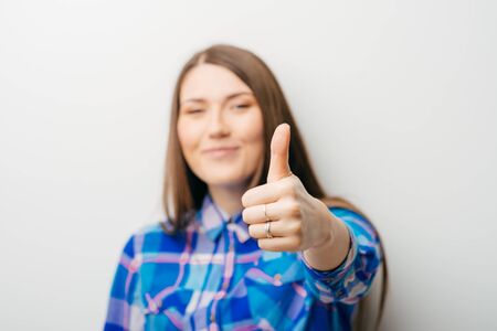 beautiful long-haired girl showing ok thumb isolated on white backgroundの写真素材