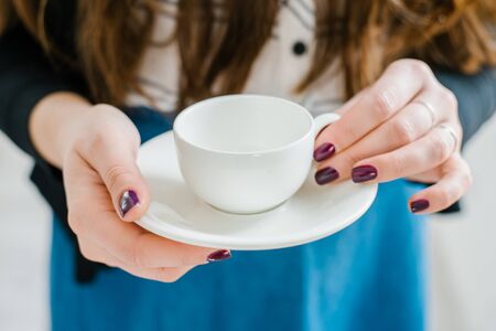young girl in glasses with white cup and saucerの写真素材