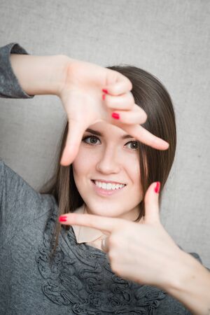 young woman shows a frame with your fingersの写真素材
