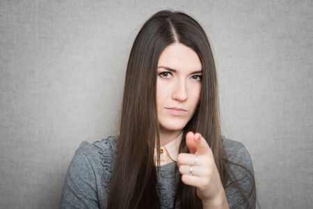 young  woman pointing at someone gesture with fingerの写真素材