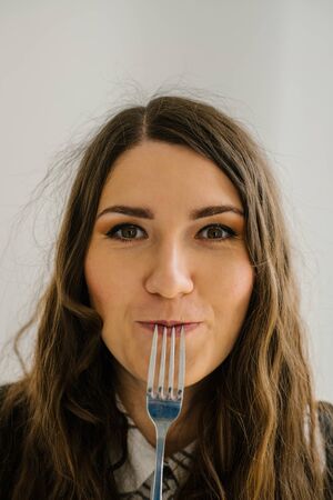 on a gray background young girl with an empty fork