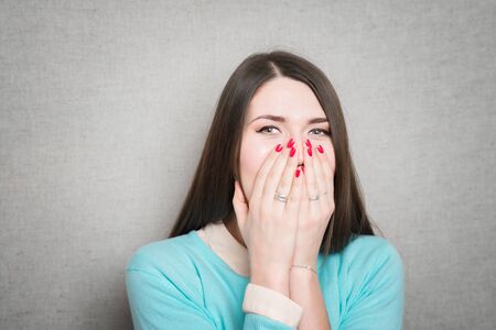 Beautiful young woman covering the face with her handの写真素材