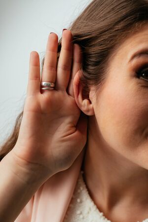 on a gray background young girl overhearsの写真素材