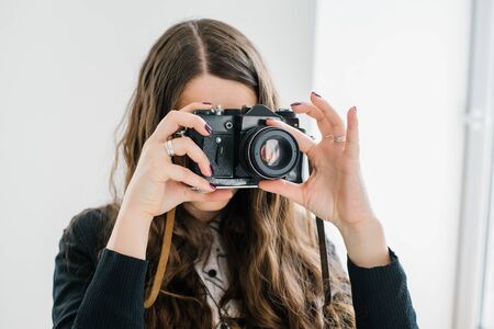 long-haired brunette girl photographed on an old cameraの写真素材