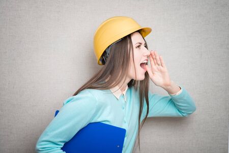 woman with helmet and folders. isolated on gray backgroundの写真素材