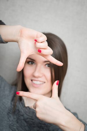 young woman shows a frame with your fingersの写真素材