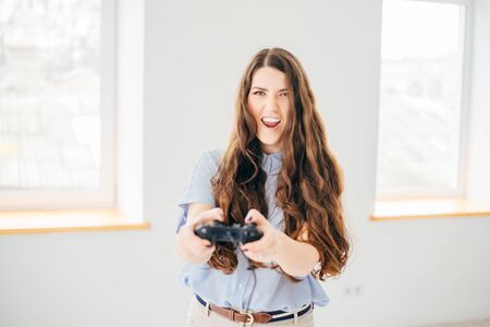 Happy woman playing video game near the window at home