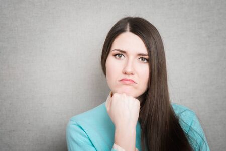 portrait of a worried young woman with a pensive gestureの写真素材