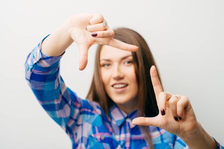 young woman shows a frame with fingersの写真素材