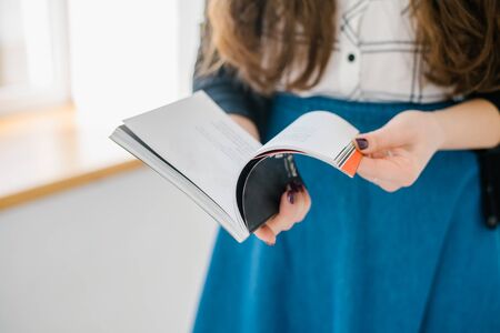 hands of a young girl holding a magazine