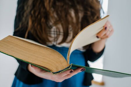 female hands Leafs big old book close up
