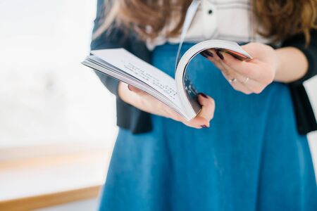 hands of a young girl holding a magazineの写真素材