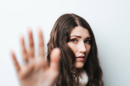 on a white background young girl with long hair shows stopの写真素材