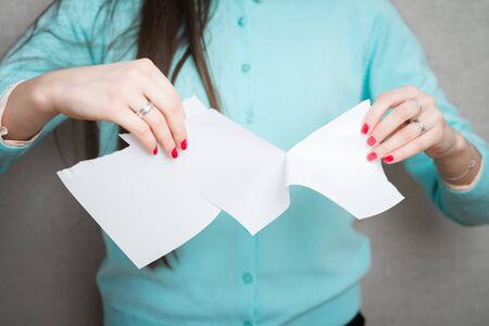 Breaking contract. Furious young woman tearing up paperの写真素材
