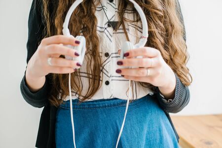beautiful brunette girl holding a white headphones